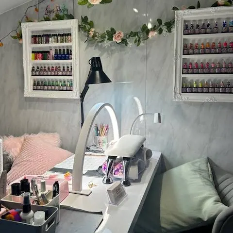 Laura's home nail salon with a nail desk, lamp and shelves of gel colours